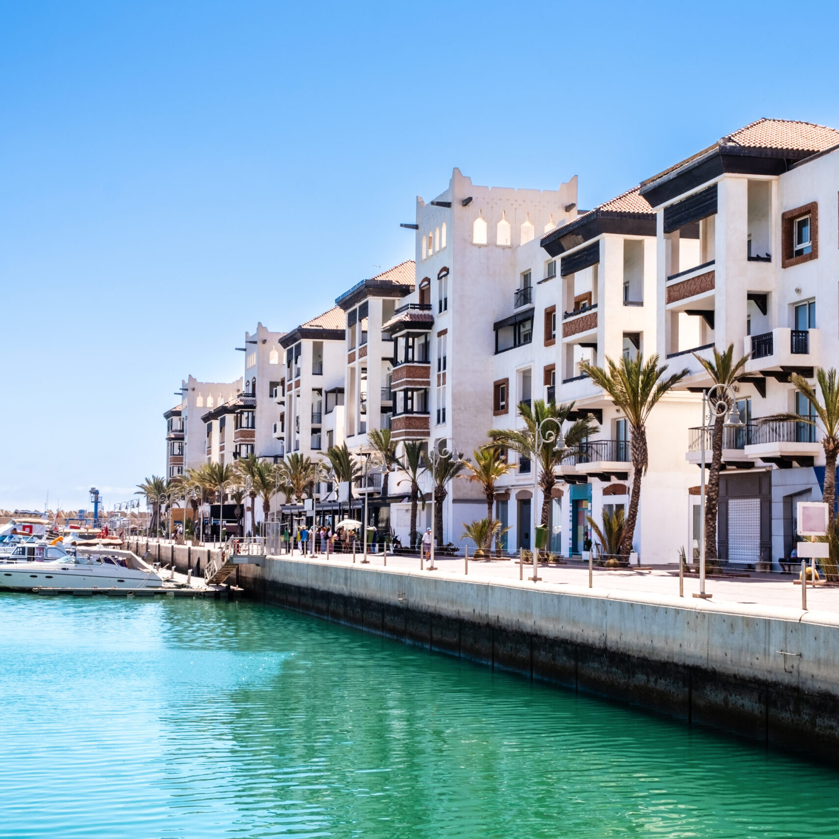Agadir Marina with luxury apartments, boats in harbor, shops and restaurants. Popular tourist destination in Moroccan seaside resort on shore of Atlantic ocean in Africa.